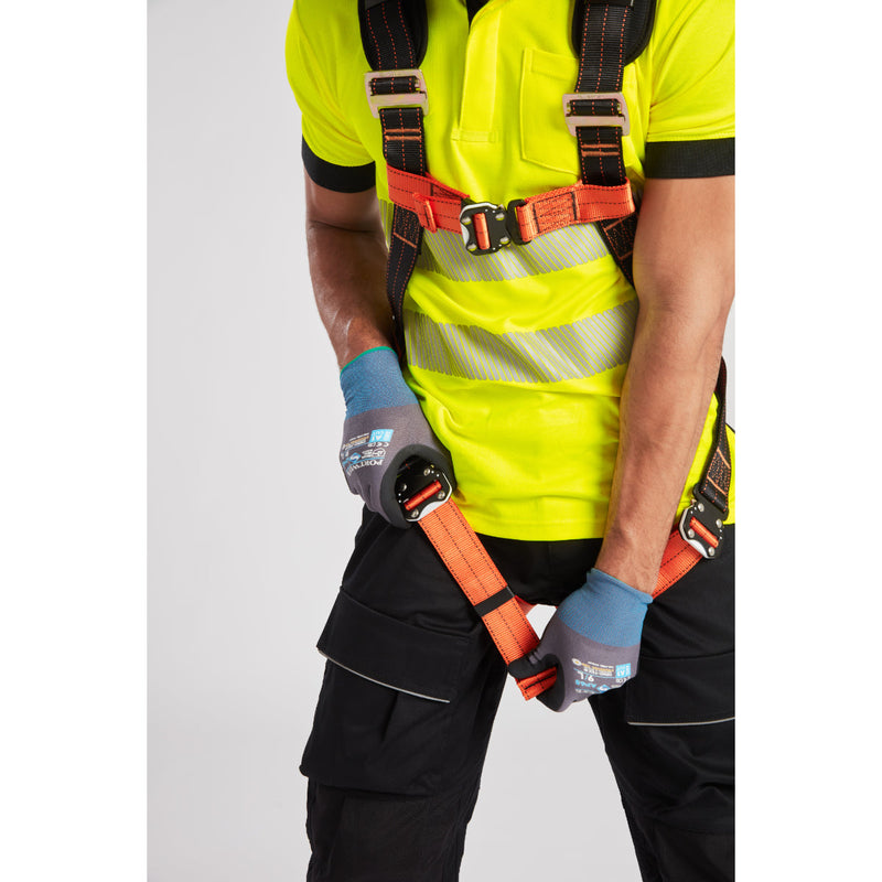 Worker wearing the Portwest PW3 harness trousers connected to a safety lanyard for fall protection.
