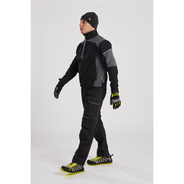 Model in an industrial setting wearing the Portwest PW3 jacket with matching work trousers and gear.