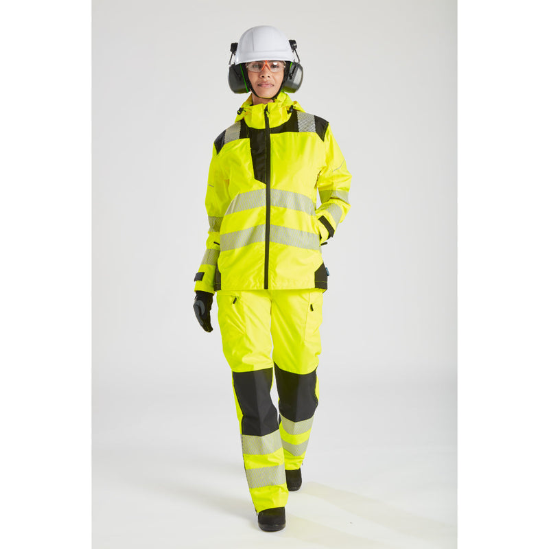 Woman in full workwear, including the yellow Portwest PW3 rain jacket and a hard hat.