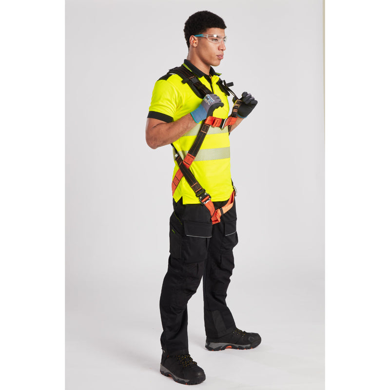 Rooftop worker inspecting safety lanyard and harness connection for secure attachment