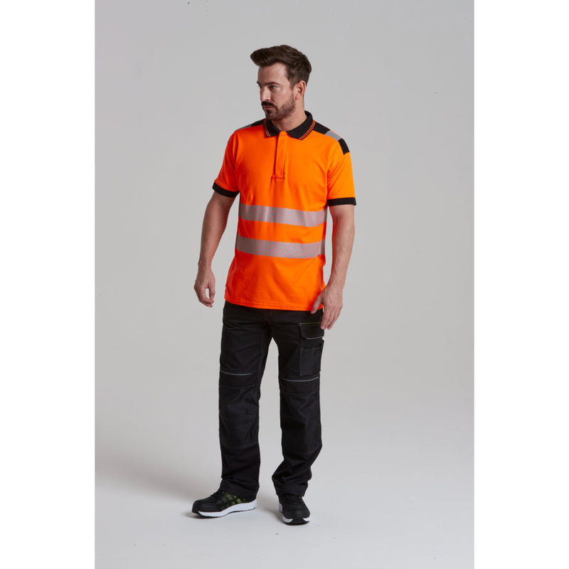 A man wearing the work trousers with a hi-vis polo shirt.