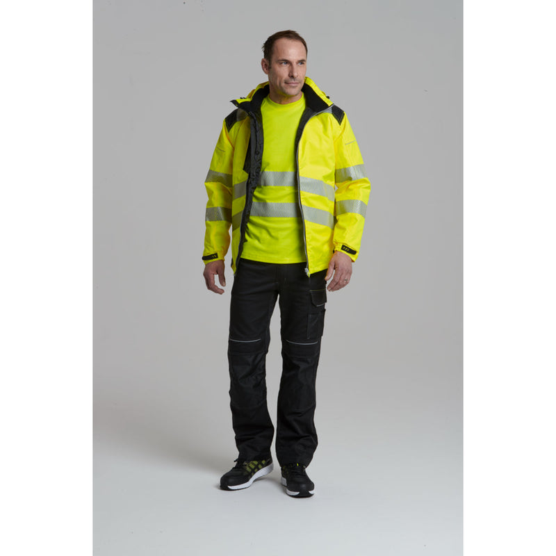 A man using a tool while dressed in the Portwest hi-vis winter jacket and trousers.