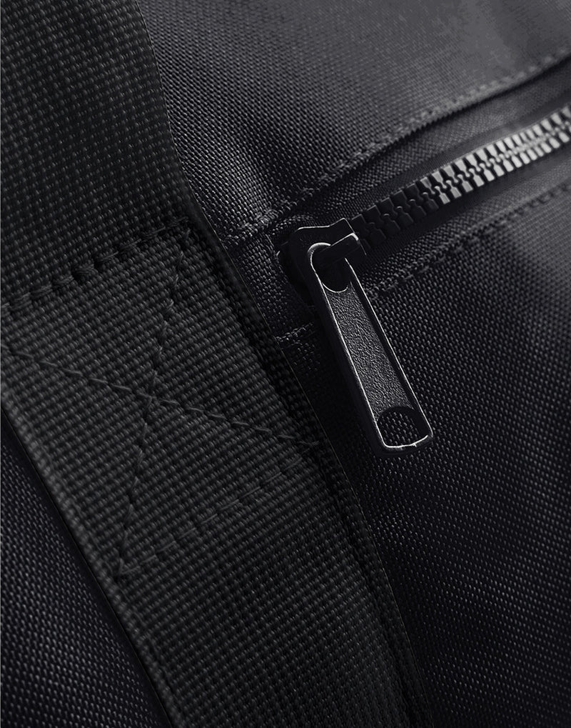 Side profile of the black mini essential backpack.