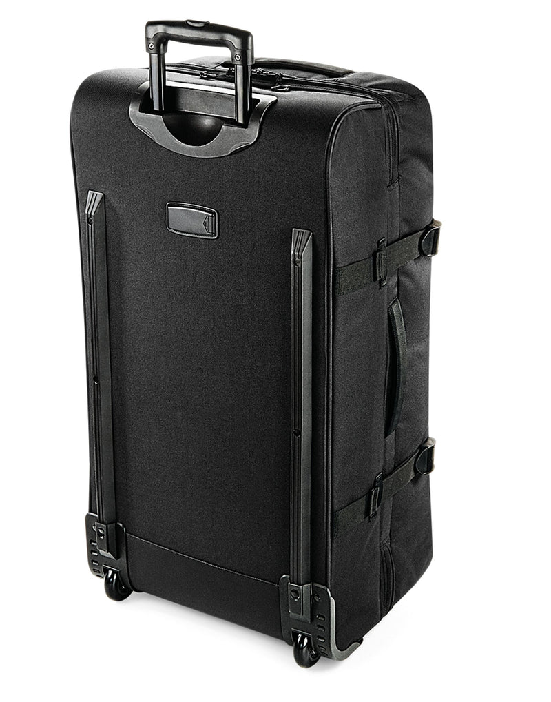Side view of the black Bagbase Escape Check-In Wheelie, with its sturdy side grab handle and compression straps.