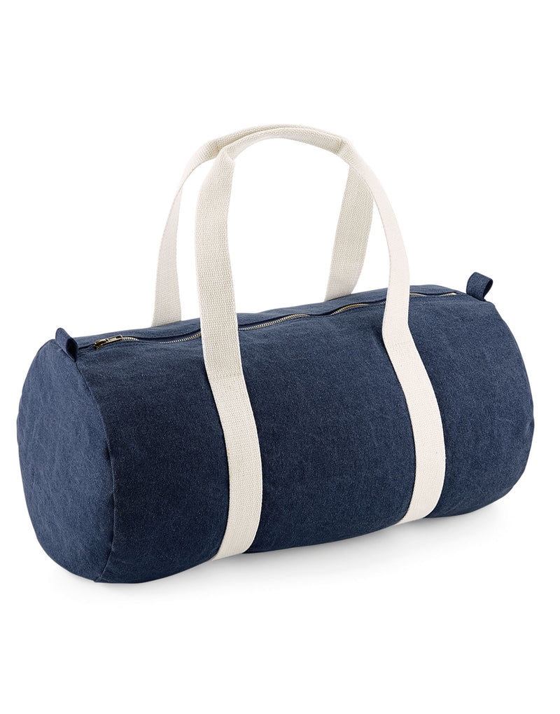 Front view of the Bagbase Denim Barrel Bag in a blue denim wash, featuring cotton webbing carry handles.