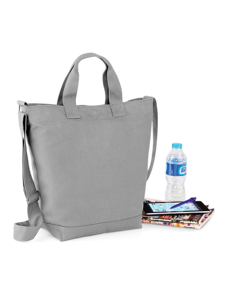 Side profile of the navy Bagbase Canvas Day Bag, illustrating its practical size and shape.
