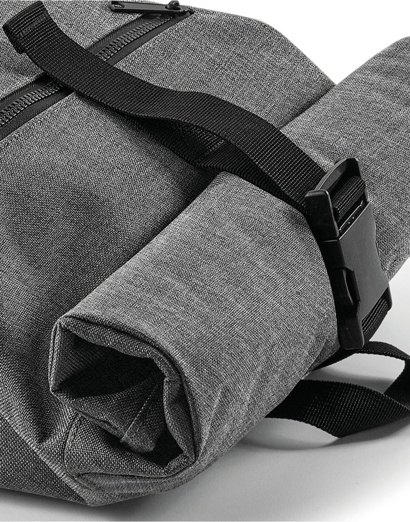 Angled view showcasing the textured material of the graphite grey Bagbase Roll-Top Backpack.