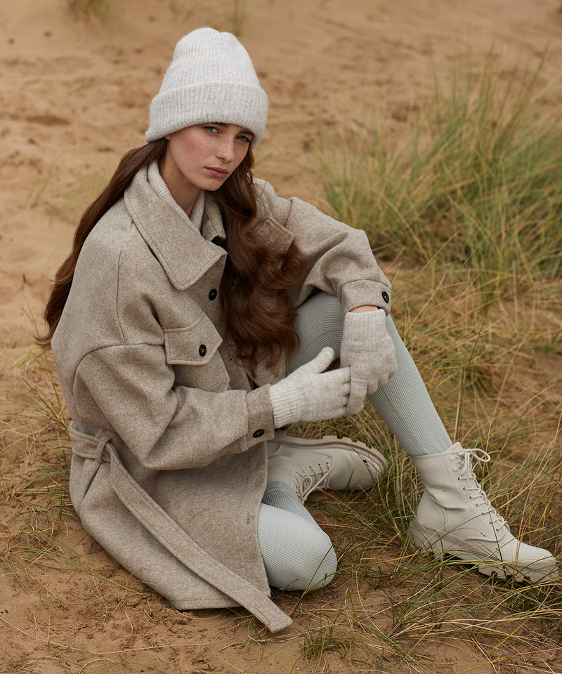 Woman wearing a grey marl Beechfield B386 beanie, looking to the side.