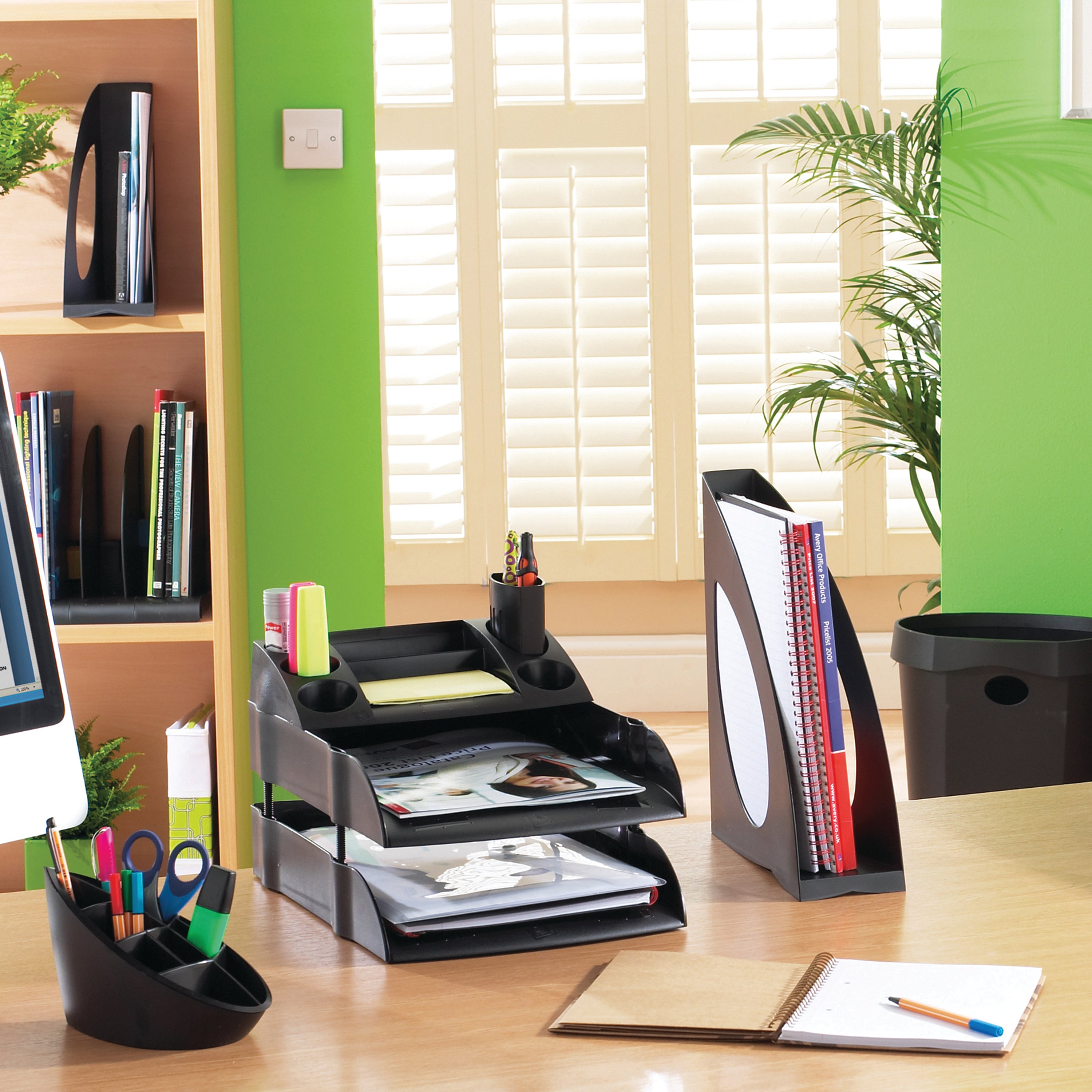 An eco-friendly black pen pot holding various pens and pencils.