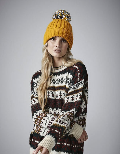 Profile view of a woman wearing the Beechfield B390 recycled pom pom beanie.