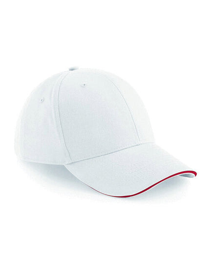 Flat lay of a white Beechfield B20 cap with classic red sandwich peak trim.