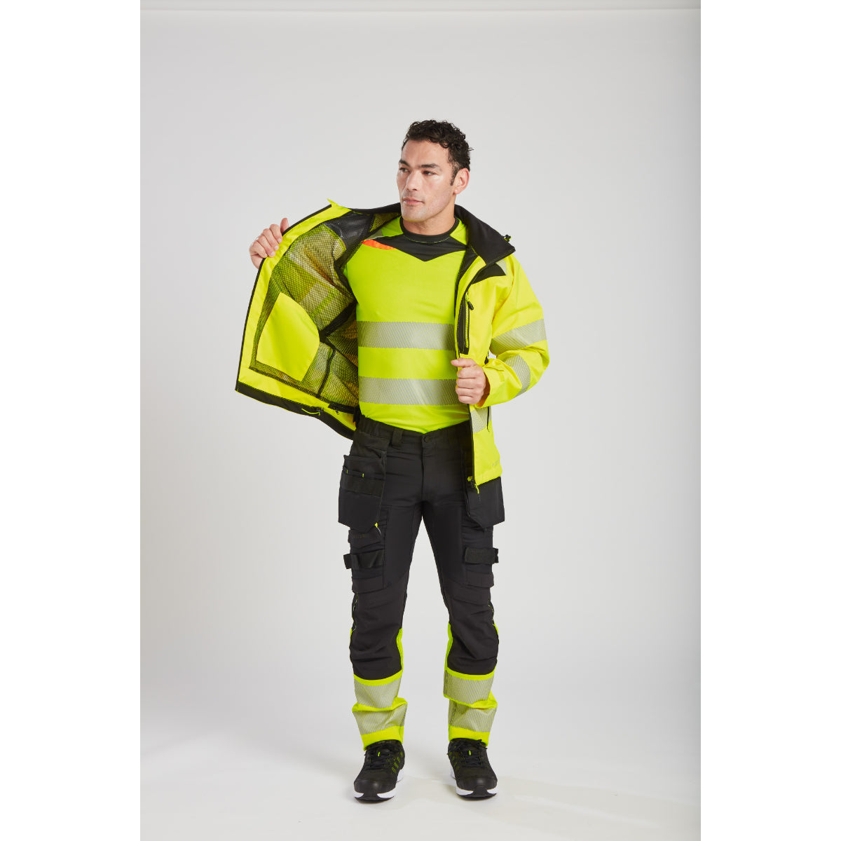 Side view of a worker wearing the Portwest DX4 Hi-Vis rain jacket.