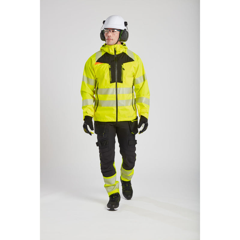Worker communicating on-site, equipped with Portwest protective gear.