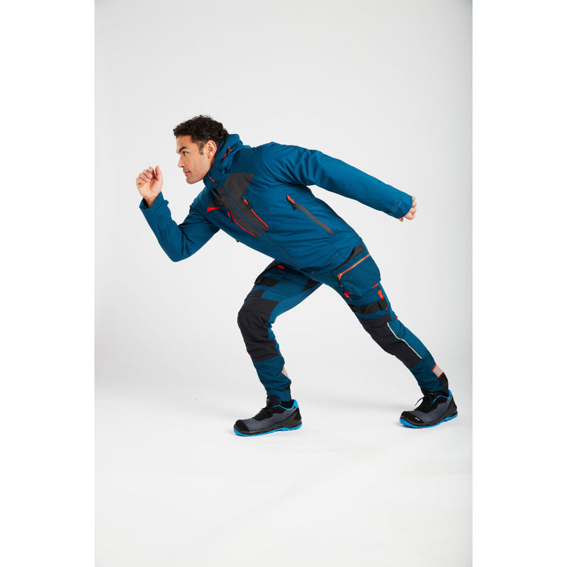 Side profile of a model wearing the metro blue Portwest Shell Jacket.