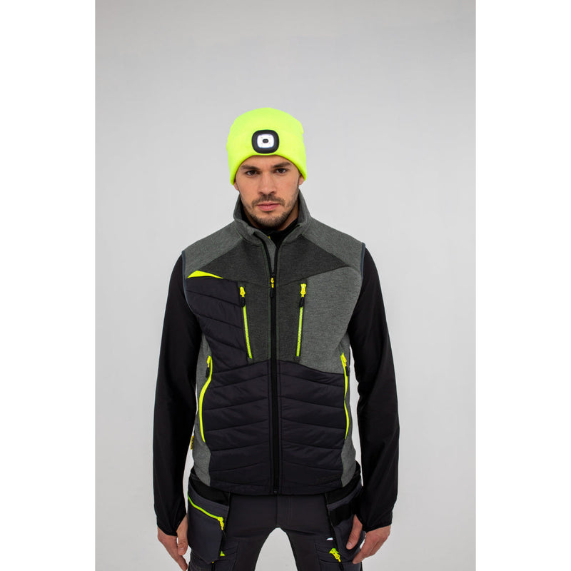 Man layering a Portwest DX4 Hybrid Baffle Gilet over a long-sleeve top outdoors.