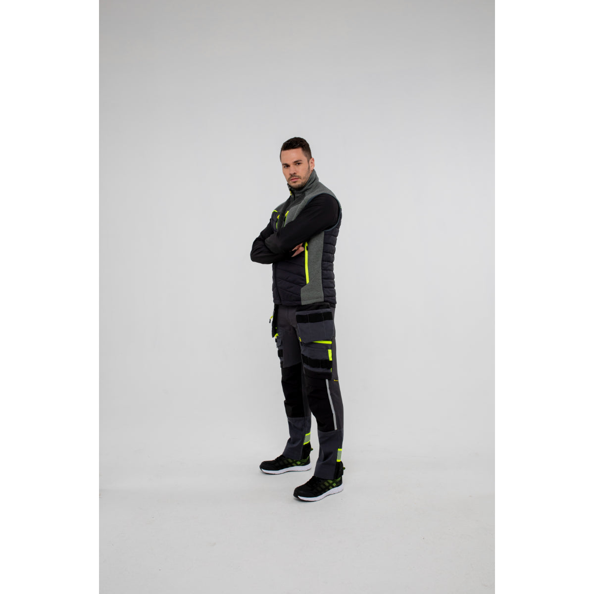 Side view of a man layering a Portwest DX4 Zip Base Layer under a gilet.