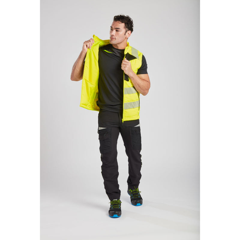 Man in Portwest DX4 Hi-Vis Softshell Bodywarmer demonstrating reaching motion.