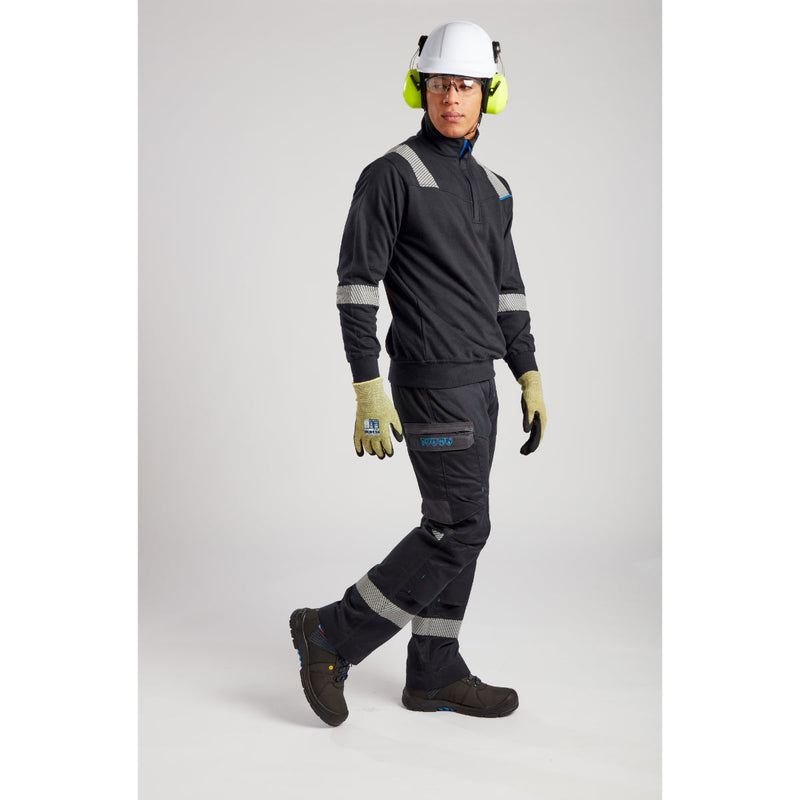 Worker in FR gear including Portwest helmet with attached ear protectors.