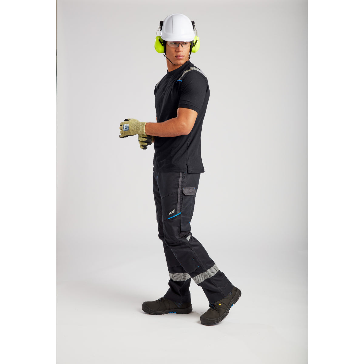 Construction worker in complete safety attire with helmet, hearing protection and moisture-wicking black uniform