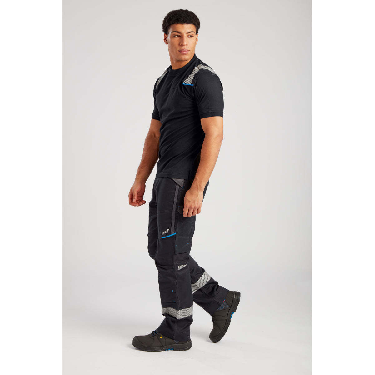 Outdoor apparel set with black athletic shirt, multi-pocket pants with reinforced knees and sturdy hiking shoes