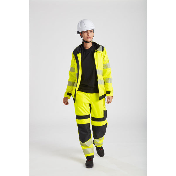 Female construction worker in bright yellow reflective jacket and pants with white helmet and safety shoes