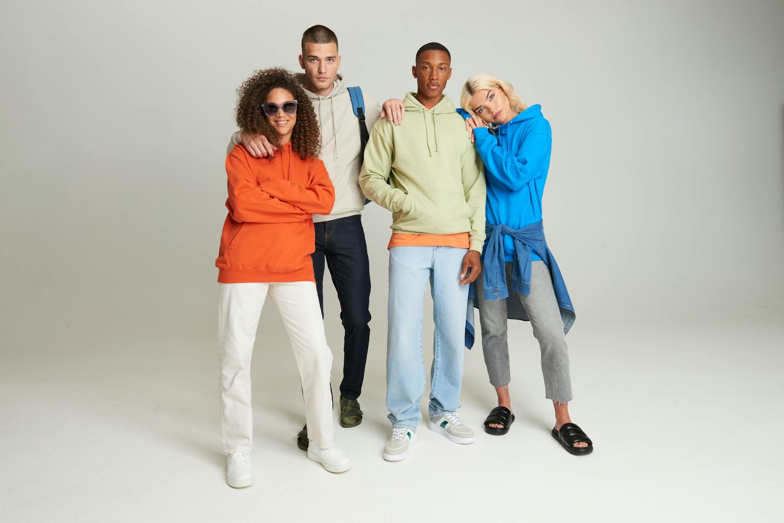 Lifestyle shot of various colorful AWDis Just Hoods hoodies being worn.