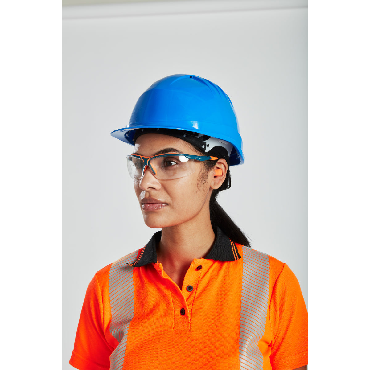 A worker wearing a Portwest helmet with clip-on ear defenders.