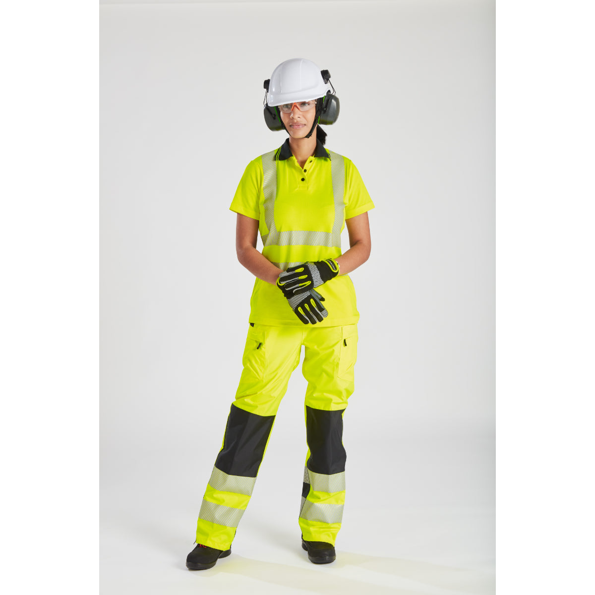Side view of a model in the full Portwest PW3 hi-vis women's rainwear set.