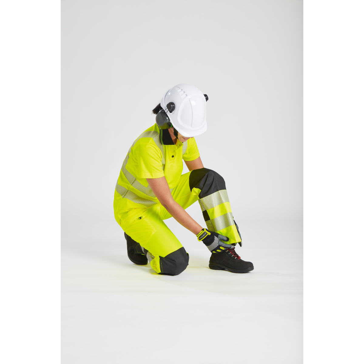 Side profile of a model in the Portwest hi-vis women's rain trousers and jacket.