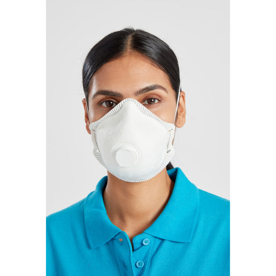 Woman wearing white protective face mask with exhalation valve and elastic ear loops, dressed in blue polo shirt