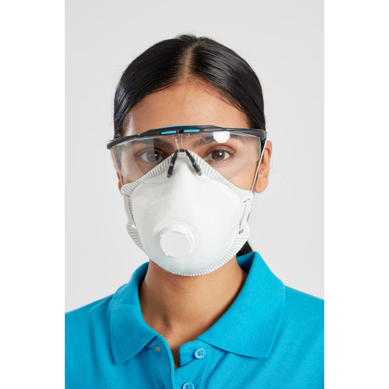 Woman in blue polo shirt wearing white respirator mask with valve and transparent safety goggles