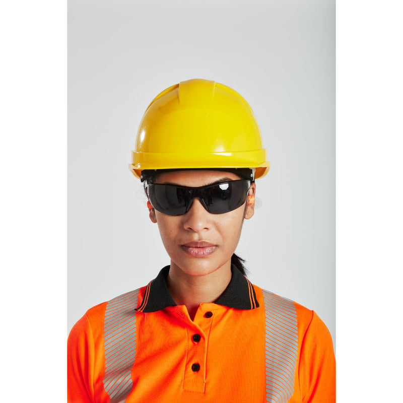 Worker wearing Portwest safety glasses while reviewing documents on a tablet.