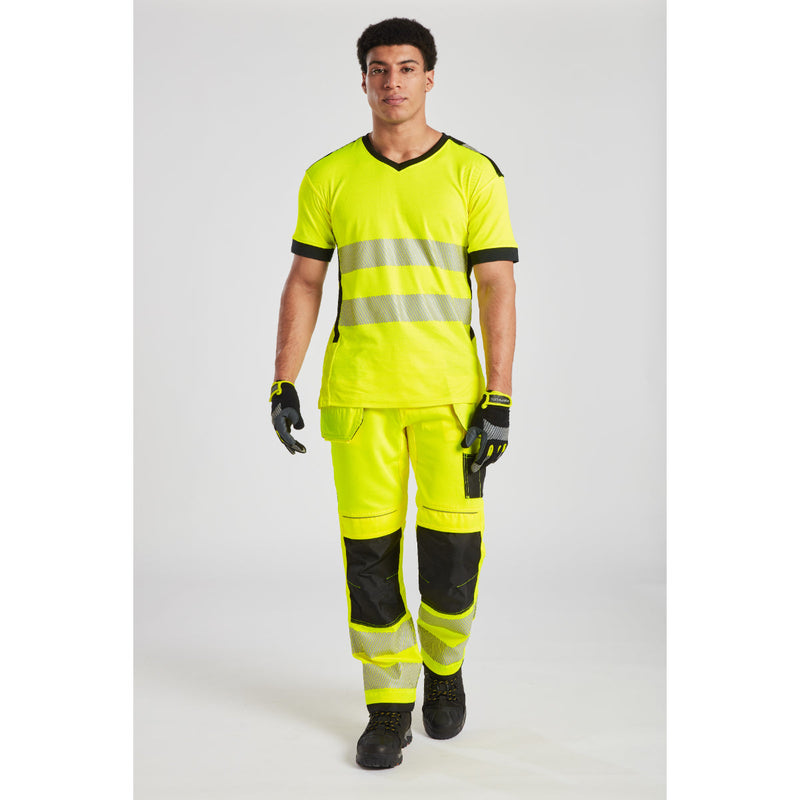 Man in hi-vis orange/navy PW3 trousers at a work site.