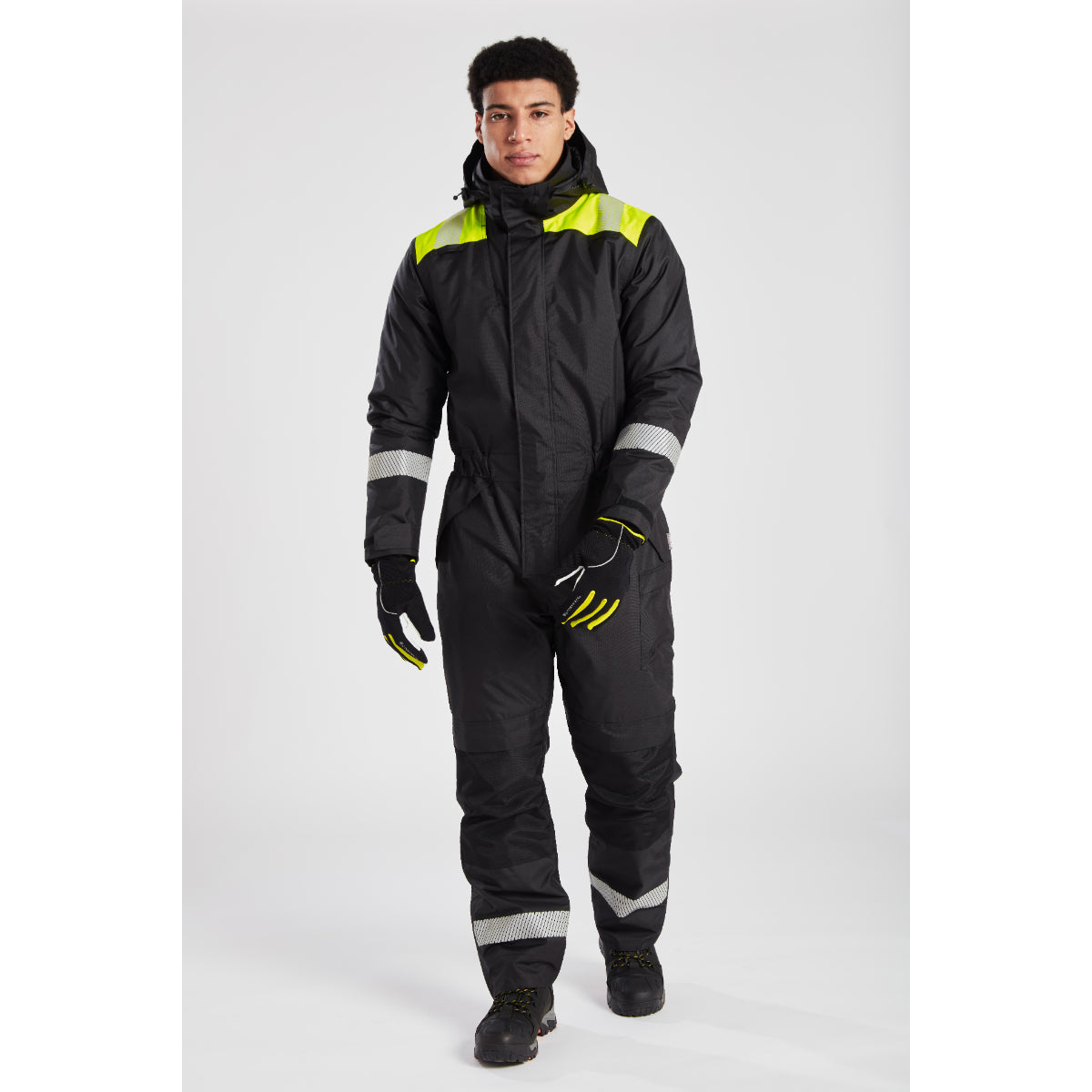 Front view of a model wearing the black Portwest PW3 Winter Coverall with reflective tape.