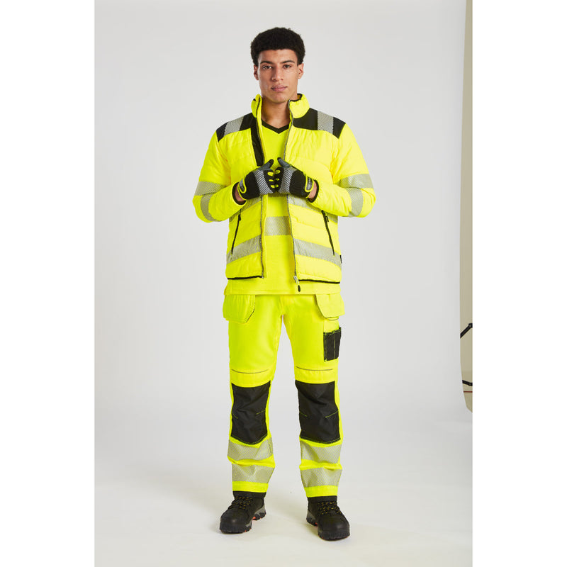 Worker wearing the orange/navy Portwest T501 hi-vis trousers.