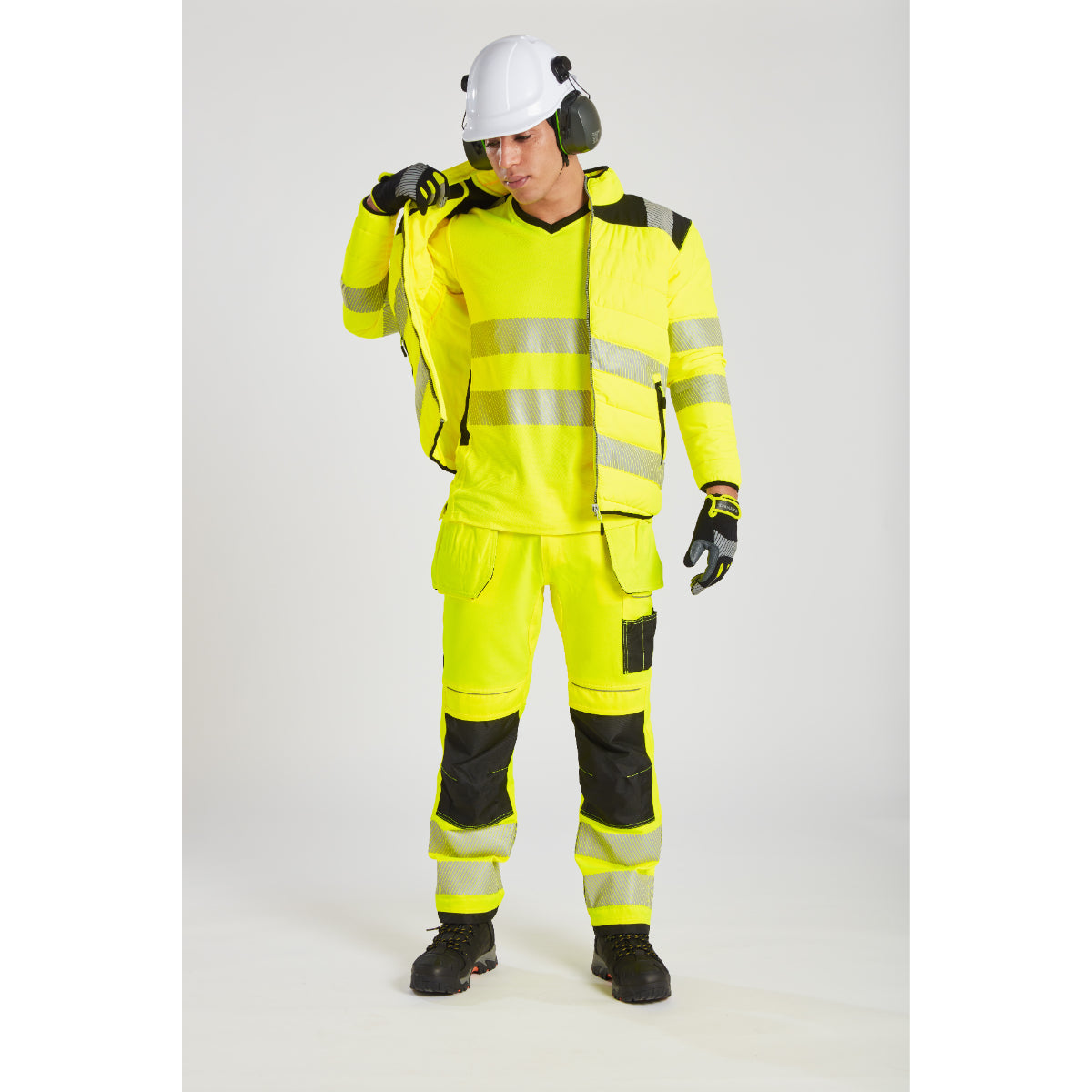 Model in an yellow Portwest PW3 Baffle Jacket with a safety helmet.