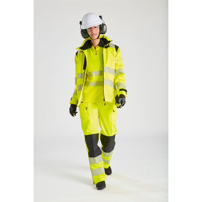 Side view of a woman in the yellow Portwest PW3 rain jacket, showing reflective tape detail.
