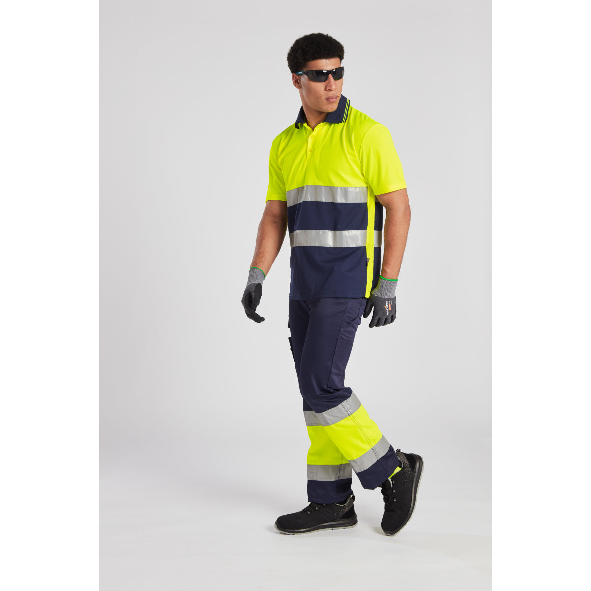 Rear view of a model in the Portwest Hi-Vis Lightweight Trouser with matching polo.