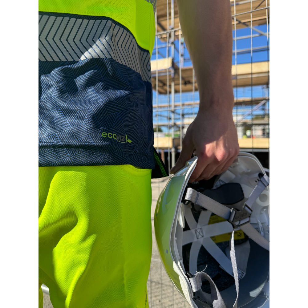Side view of Leo EcoViz T-shirt with hi-vis yellow fabric and worker holding safety helmet.