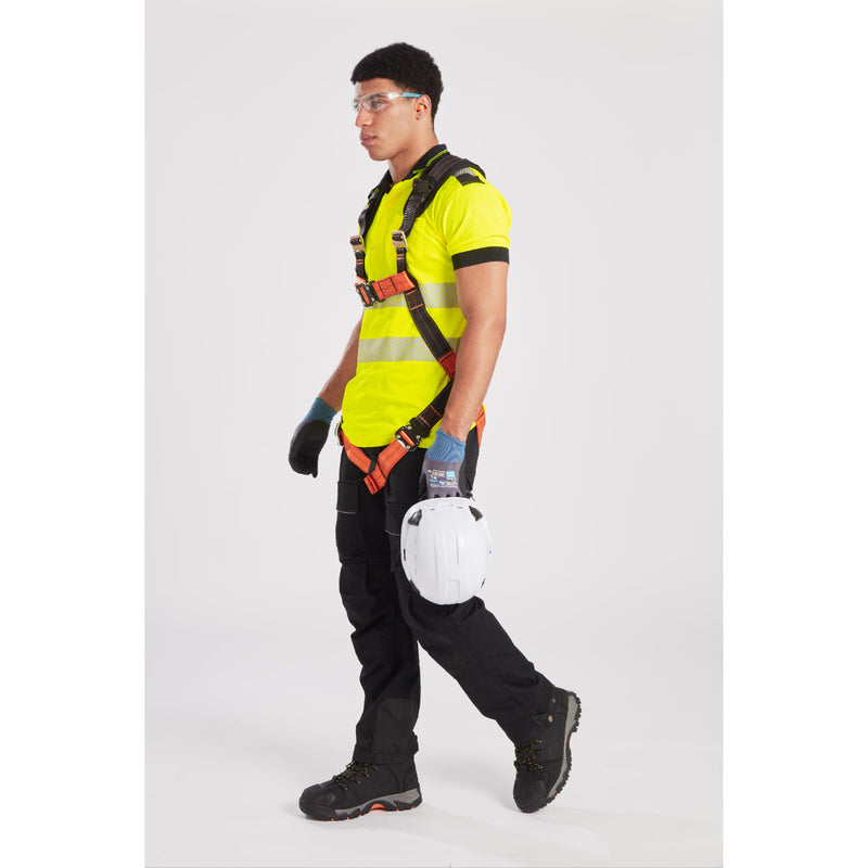 Worker in full PPE, including helmet and harness, ready for elevated worksite activity.