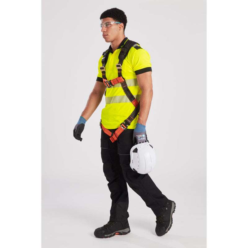 Worker adjusting harness and helmet, demonstrating safety compliance on site.