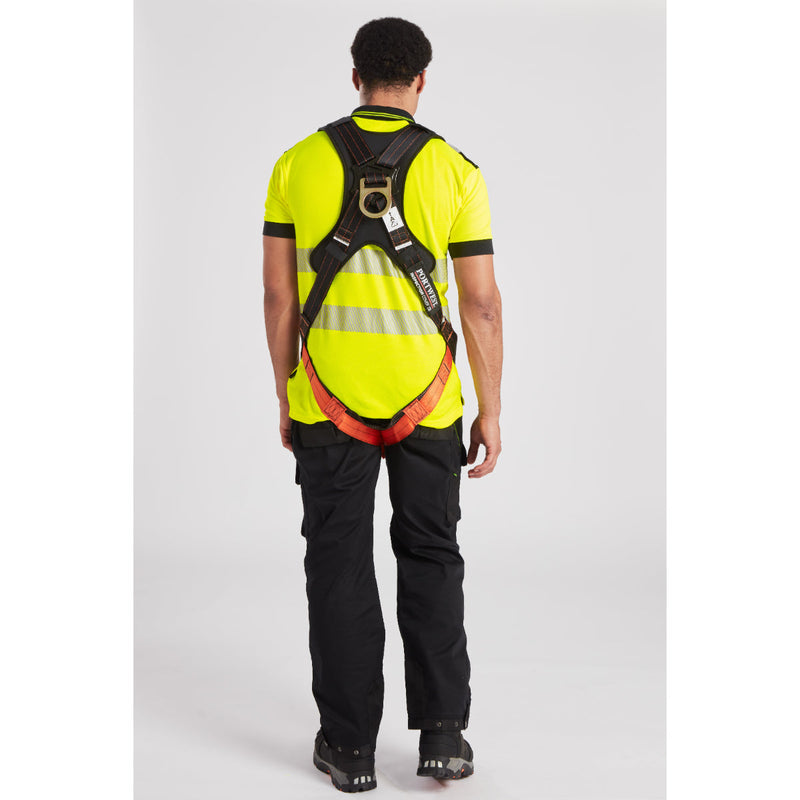 Worker adjusting safety helmet and harness, demonstrating proper PPE usage at height.