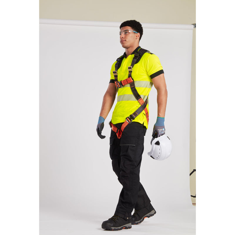 Worker adjusting helmet and harness straps while preparing for rooftop safety inspection