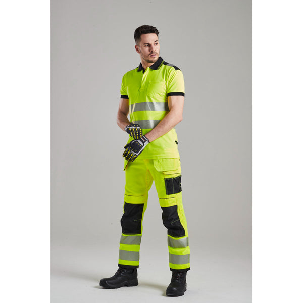 Worker wearing Portwest hi-vis jacket, trousers, and mechanic's gloves.