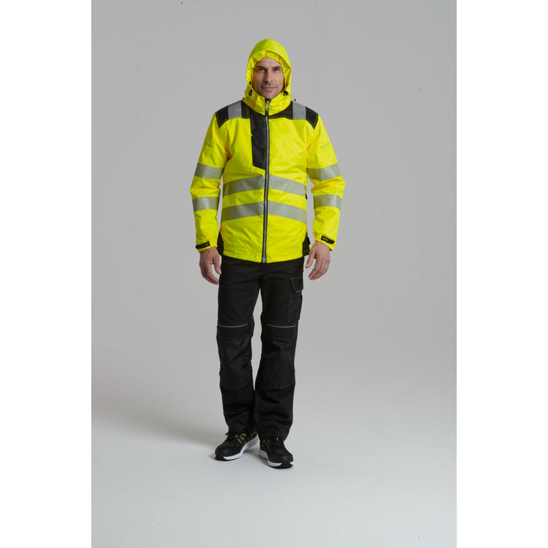 A worker kneeling while wearing the hi-vis winter jacket and trousers.