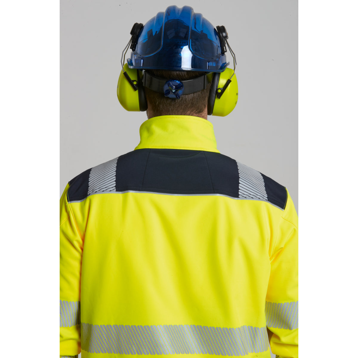 Worker wearing Portwest Softshell, helmet, and safety glasses.