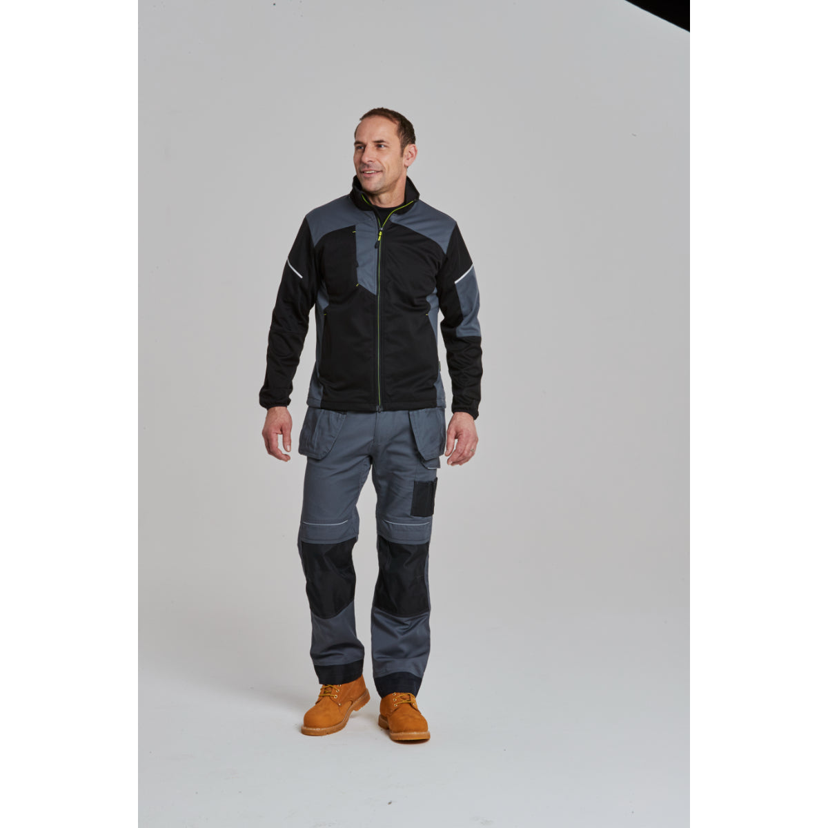 Worker in Flex Shell Jacket, trousers, and safety boots.