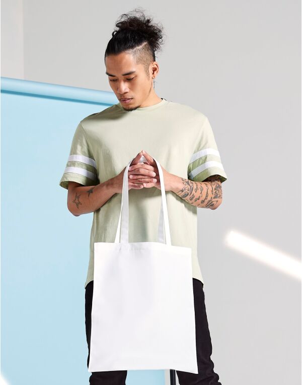 Angled view of the Bagbase Sublimation Shopper, showcasing its spacious main compartment and sturdy canvas handles.