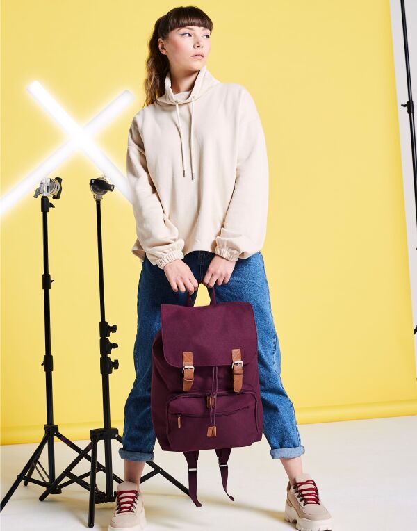Angled view of the caramel-colored Bagbase Vintage Laptop Backpack, showcasing its washed canvas material.