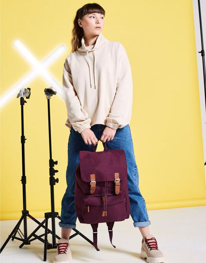 Angled view of the caramel-colored Bagbase Vintage Laptop Backpack, showcasing its washed canvas material.